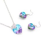 Wholesale heart crystal jewelry set with rainbow AB (Aurore Boreale) and blue Swarovski elements, featuring a pave accent heart on 18K white gold plated brass from JuneJewelry.com.