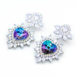 Swarovski Element heart crystal dangle earrings with a single, perfectly cut crystal, available in Vitrail Light (iridescent purple-green) and Bermuda Blue (deep electric blue) color effects.