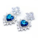 Swarovski Element heart crystal dangle earrings with a single, perfectly cut crystal, available in Vitrail Light (iridescent purple-green) and Bermuda Blue (deep electric blue) color effects.