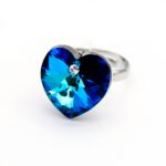 Swarovski Element adjustable heart crystal ring shown in three colors: iridescent golden yellow AB, dual-tone purple/blue AB, and deep sapphire blue, all featuring a large heart crystal.