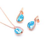 Wholesale teardrop crystal jewelry set in rose gold plating with large blue faceted crystal pendant and matching pave-accented earrings from JuneJewelry.com – unique and high-quality.