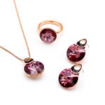 Wholesale crystal round jewelry set in rose gold plating with a large faceted white crystal ring, pendant, and drop earrings with black enamel detail from JuneJewelry.com – unique and high-quality.