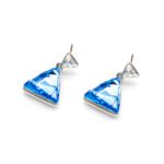A close-up of a single, brilliant triangle (Trillion cut) Swarovski Element stud earring set in a simple, minimalist metal bezel.