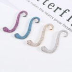 Wholesale snake earrings featuring white zircon pave and green eyes on real gold plated copper from JuneJewelry.com.