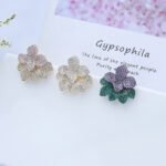 Wholesale flower zircon earrings with white pavé crystals on real gold plated copper from JuneJewelry.com – luxury floral studs for bulk orders.