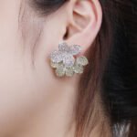 Wholesale flower zircon earrings with white pavé crystals on real gold plated copper from JuneJewelry.com – luxury floral studs for bulk orders.