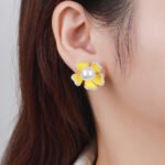 Wholesale pearl flower earrings with lavender enamel petals and zircons on 14K gold plated brass from JuneJewelry.com – unique floral jewelry for bulk purchase.