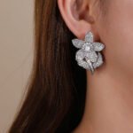 Wholesale panther head earrings with white zircon pavé and green eyes on silver plated copper from JuneJewelry.com – luxury animal jewelry.