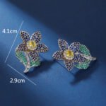 Wholesale panther head earrings with white zircon pavé and green eyes on silver plated copper from JuneJewelry.com – luxury animal jewelry.