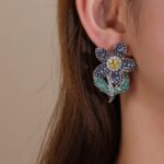 Wholesale panther head earrings with white zircon pavé and green eyes on silver plated copper from JuneJewelry.com – luxury animal jewelry.