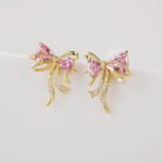Wholesale Pink Ribbon Earrings with trillion-cut pink crystals and 925 silver needles on gold plated brass from JuneJewelry.com.
