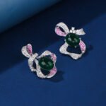 Wholesale red ribbon earrings with green zircons and 925 silver needles from JuneJewelry.com – unique bow-knot fashion jewelry for bulk buyers.