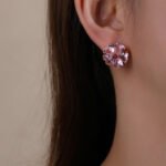 Wholesale pink flower earrings with heart-shaped zircon and 925 silver pins from JuneJewelry.com – cherry blossom fashion jewelry for bulk orders.