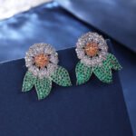 Wholesale zircon flower earrings with white pavé petals on real gold plated copper from JuneJewelry.com – luxury floral studs for bulk orders.