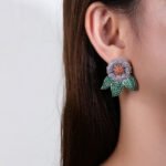Wholesale zircon flower earrings with white pavé petals on real gold plated copper from JuneJewelry.com – luxury floral studs for bulk orders.