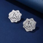 Wholesale floral zircon earrings with white pavé petals on real gold plated copper from JuneJewelry.com – luxury blossom studs for bulk orders.