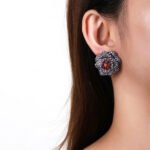 Wholesale floral zircon earrings with white pavé petals on real gold plated copper from JuneJewelry.com – luxury blossom studs for bulk orders.