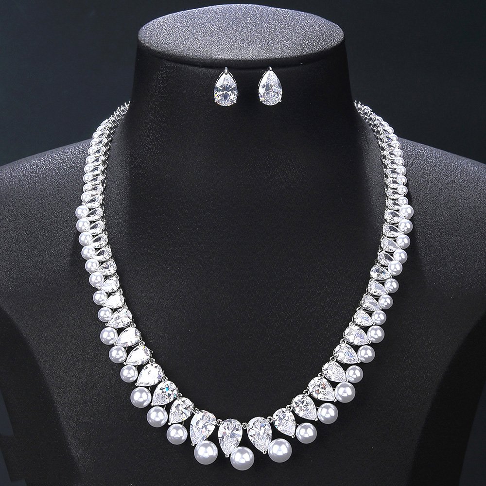 Wholesale teardrop pearl set with pear-cut zircons and white shell pearls on gold plated copper from JuneJewelry.com – bridal jewelry for bulk orders.