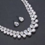 Wholesale teardrop pearl set with pear-cut zircons and white shell pearls on gold plated copper from JuneJewelry.com – bridal jewelry for bulk orders.