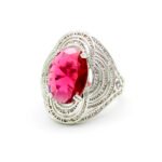 Wholesale blue zircon ring with oval-cut center stone and tiered halo design on gold plated copper from JuneJewelry.com – adjustable cocktail jewelry for bulk orders.