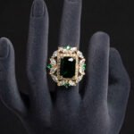 Wholesale emerald cut ring with a large red zircon and 18K gold plated copper band from JuneJewelry.com – adjustable luxury jewelry for bulk orders.