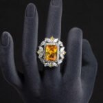 Wholesale emerald cut ring with a large red zircon and 18K gold plated copper band from JuneJewelry.com – adjustable luxury jewelry for bulk orders.