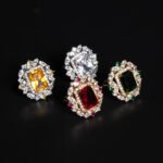 Wholesale emerald cut ring with a large red zircon and 18K gold plated copper band from JuneJewelry.com – adjustable luxury jewelry for bulk orders.