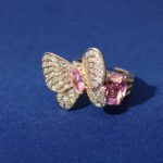 Wholesale butterfly open ring with pink zircon stones and real gold plating on copper from JuneJewelry.com – adjustable fashion ring for bulk orders.