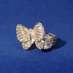Wholesale butterfly open ring with pink zircon stones and real gold plating on copper from JuneJewelry.com – adjustable fashion ring for bulk orders.