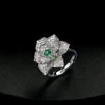 Wholesale floral zircon ring with emerald green center stone and gold plated copper from JuneJewelry.com – adjustable flower ring for bulk orders.