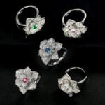 Wholesale floral zircon ring with emerald green center stone and gold plated copper from JuneJewelry.com – adjustable flower ring for bulk orders.