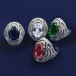 Wholesale blue zircon ring with oval-cut center stone and tiered halo design on gold plated copper from JuneJewelry.com – adjustable cocktail jewelry for bulk orders.