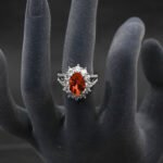 Wholesale luxury zircon ring featuring a large red oval stone on gold plated copper from JuneJewelry.com – adjustable high-quality jewelry for bulk buyers.