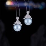 High-end light luxury crown pearl jewelry set wholesale featuring a delicate micro-pave zircon tiara cap pendant necklace and matching pearl stud earrings on junejewelry.com