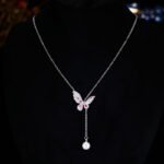 Niche light luxury butterfly zircon jewelry set wholesale featuring an intricate micro-pave crystal butterfly Y-shaped choker necklace with a drop pearl and matching butterfly stud earrings on junejewelry.com