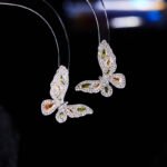 Niche light luxury butterfly zircon jewelry set wholesale featuring an intricate micro-pave crystal butterfly Y-shaped choker necklace with a drop pearl and matching butterfly stud earrings on junejewelry.com