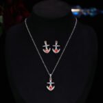 Niche Western style anchor cross jewelry set wholesale showing a brilliant micro-pave crystal ship anchor pendant necklace and matching stud earrings from junejewelry.com