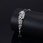 Luxury animal motif leopard head zircon jewelry set wholesale featuring a micro-pave panther head pendant necklace with an emerald green zircon teardrop tassel and matching long drop earrings from junejewelry.com