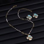 Elegant vintage French style camellia zircon jewelry set wholesale featuring a multi-layered micro-pave crystal flower pendant on an asymmetric pearl chain and matching flower stud earrings on junejewelry.com
