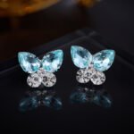 Niche summer blue crystal butterfly jewelry set wholesale featuring an aquamarine pear-cut gemstone butterfly pendant with dangling star chain tassels and matching butterfly stud earrings from junejewelry.com