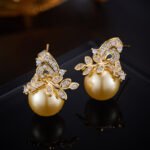 Elegant floral pearl jewelry set wholesale featuring a delicate micro-pave zircon botanical leaf crown capping a large, high-luster round pearl on a pendant necklace and matching stud earrings from junejewelry.com.
