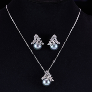 Elegant floral pearl jewelry set wholesale featuring a delicate micro-pave zircon botanical leaf crown capping a large, high-luster round pearl on a pendant necklace and matching stud earrings from junejewelry.com.