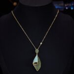 Western heavy-craft geometric conch shell zircon jewelry set wholesale featuring a curved, bi-color micro-pave emerald green and turquoise blue fold pendant necklace and matching drop earrings from junejewelry.com
