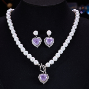 Light luxury ice-cracked zircon heart pearl jewelry set wholesale featuring a classic round pearl strand necklace with a front-facing OT toggle clasp, a micro-pave halo peach heart pendant, and matching pearl-topped drop earrings from junejewelry.com