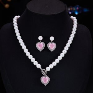 Light luxury ice-cracked zircon heart pearl jewelry set wholesale featuring a classic round pearl strand necklace with a front-facing OT toggle clasp, a micro-pave halo peach heart pendant, and matching pearl-topped drop earrings from junejewelry.com