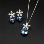 Wholesale flower jewelry set crafted from white gold plated copper with blue Swarovski element crystals and faux pearls from JuneJewelry.com.