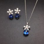 Wholesale flower jewelry set crafted from white gold plated copper with blue Swarovski element crystals and faux pearls from JuneJewelry.com.