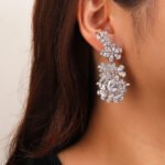 Wholesale floral zircon earrings with clear cubic zirconia petals on platinum plated brass from JuneJewelry.com – bridal chandelier drop earrings for bulk purchase.