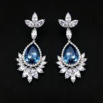 Wholesale teardrop crystal earrings with dark blue Swarovski Element crystals on platinum plated brass from JuneJewelry.com – statement dangle earrings for bulk purchase.