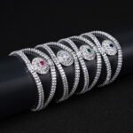 Wholesale Crystal Bangle Bracelet featuring double row baguette stones and red sunburst halo on platinum plated copper from JuneJewelry.com.